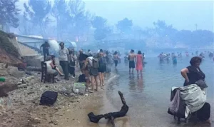Στο κόκκινο λιμανάκι επιζώντες περιμένουν τη διάσωσή τους. 